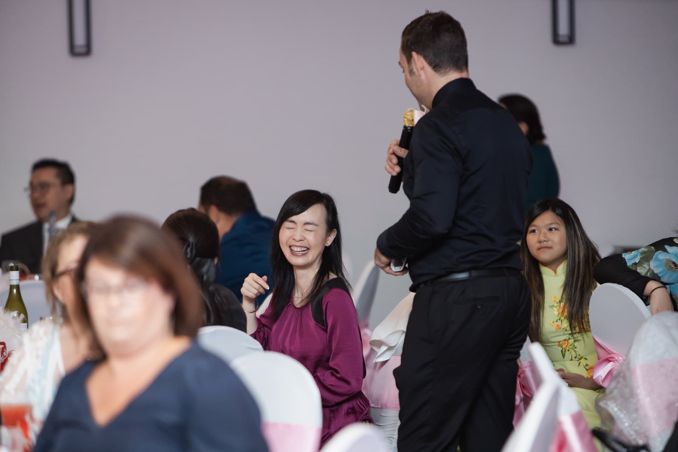 Wedding guests laughing at their table as Mike Oulton works the room